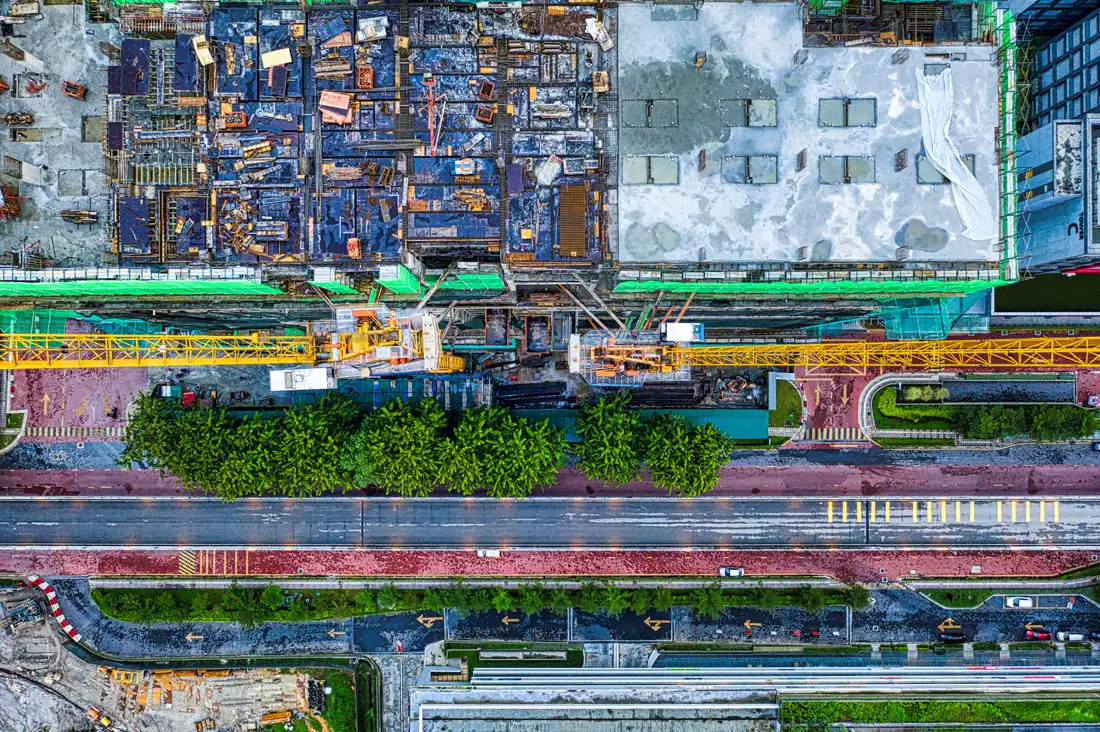 Top-down drone view of a construction site next to a highway