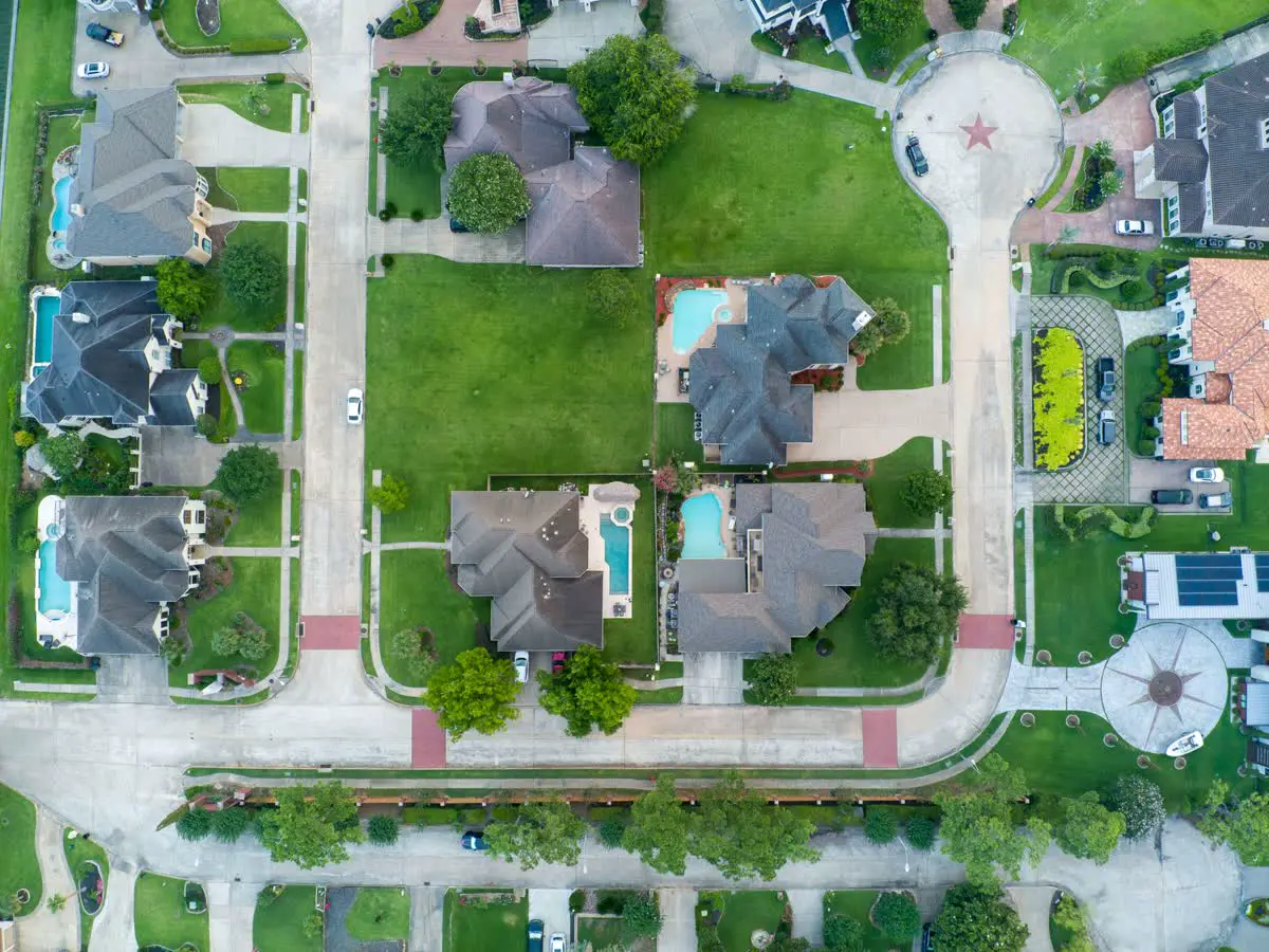 Drone view of suburban homes with pools